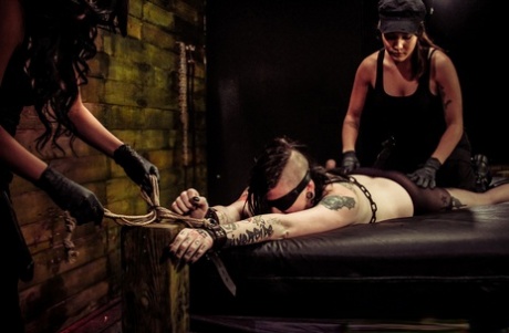 Suicide girl Jynx Hollywood is dominated by a couple of lesbians in a dungeon