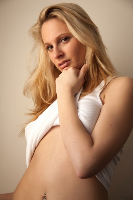 Natürliche Blondine mit hübschem Gesicht stellt ihre Möse zur Schau, während sie unten ohne herumläuft