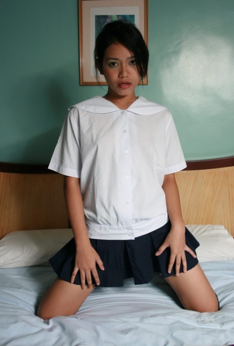 Hot Asian teen schoolgirl sheds her uniform to rub her bald pussy on the bed - pornpics.de