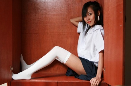 Cute Asian student showcases her bald cunt on a shelf in white OTK socks - pornpics.de
