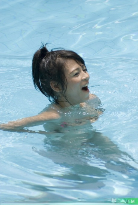Young Asian girl slips into the pool after covering nude body in suntan lotion - pornpics.de