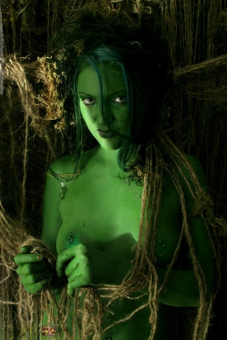 Solo girl with green skin wanders around the woods with no clothes on