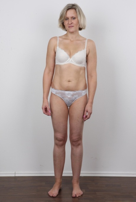 成熟的女人在脱去所有的衣服后，交叉她的腿
