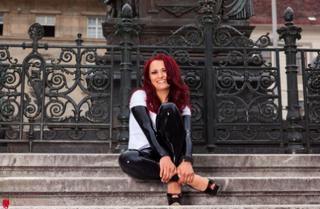 Redhead amateur Lara Larsen models on steps in latex clothing and heels