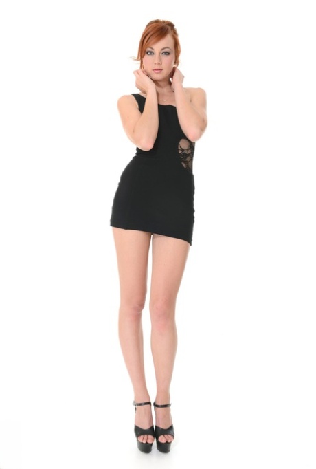 Sexy Rothaarige Elen Moore zeigt ihre langen Beine, während sie sich aus dem schwarzen Kleid schält