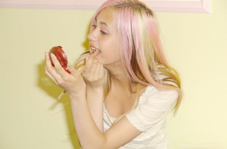 美丽的少女拿着小巧的镜子化妆