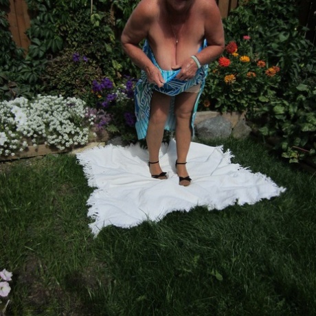 Fat nan Girdle Goddess strips to sheer pantyhose on a blanket by a flower bed - pornpics.de