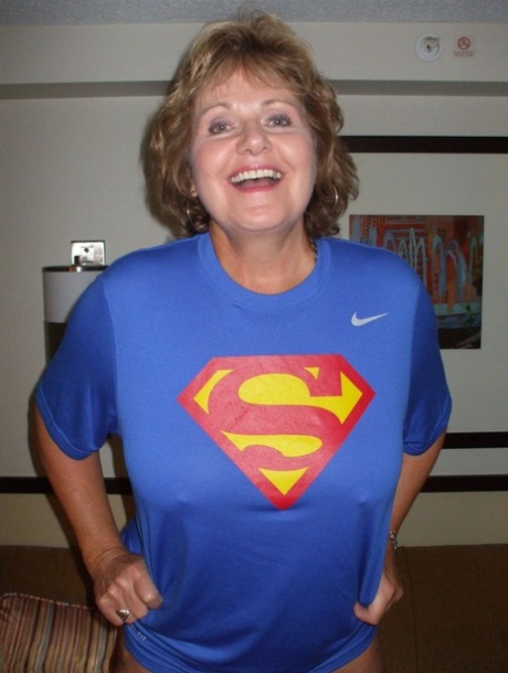 Older amateur Busty Bliss looses her big tits from a Superman T-shirt