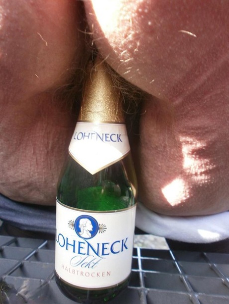 饥渴的老卡罗在户外穿着靴子张开阴部玩弄酒瓶