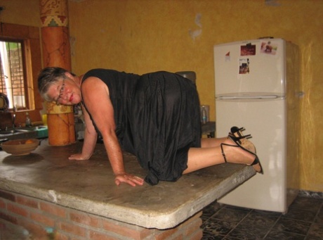 Fat oma Girdle Goddess 在厨房的一个小岛上将条纹裤袜晒成棕褐色