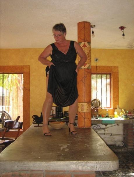 Fat oma Girdle Goddess 在厨房的一个小岛上将条纹裤袜晒成棕褐色