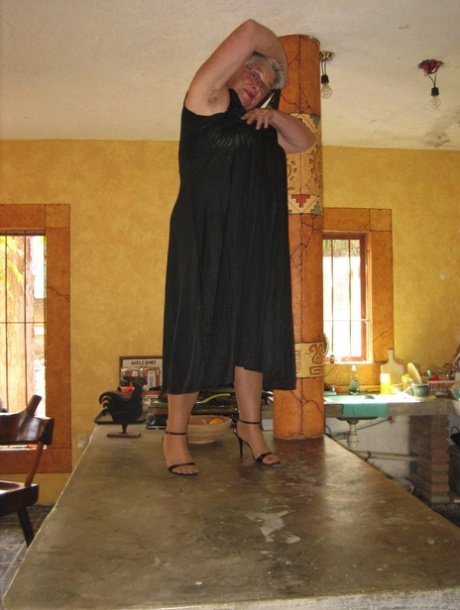 Fat oma Girdle Goddess 在厨房的一个小岛上将条纹裤袜晒成棕褐色