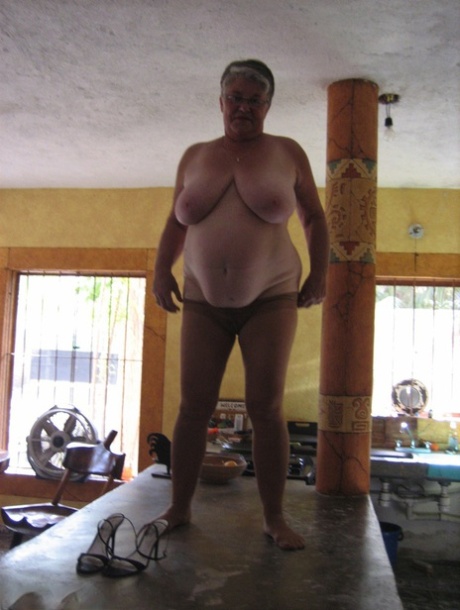 Fat oma Girdle Goddess 在厨房的一个小岛上将条纹裤袜晒成棕褐色