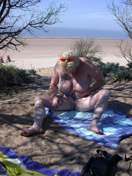 Older blonde amateur Mary Bitch takes a pee before going topless in the ocean - pornpics.de