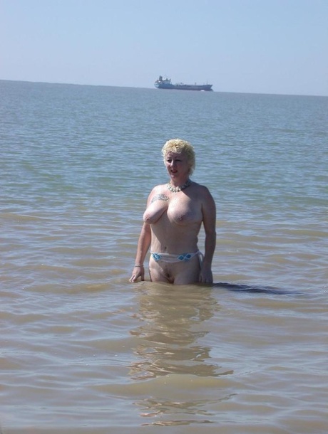 Older blonde amateur Mary Bitch takes a pee before going topless in the ocean - pornpics.de
