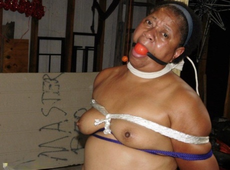 被绑在柱子上的黑木胖子戴着球塞和乳夹