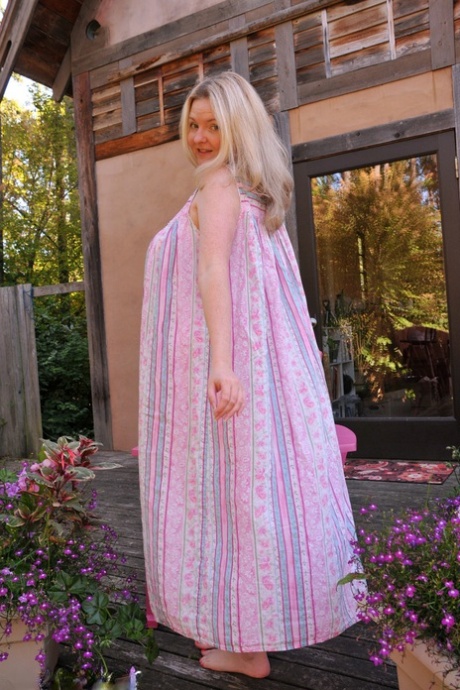 Older woman Tasty Trixie removes her nightgown to pose nude on patio