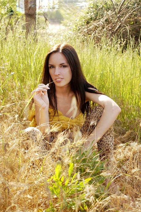 Dark haired beauty Aurita shows her pert tits while posing nude in the wild