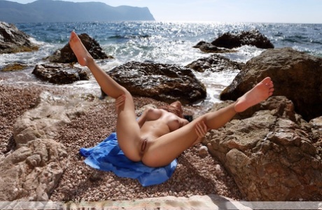 Totally naked teen Nadina L strikes great poses at the sea in incoming surf - pornpics.de