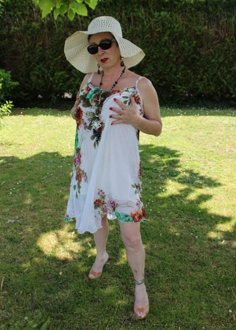 Mature amateur Mary Bitch pulls down her thong on a lawn in a sun hat - pornpics.de
