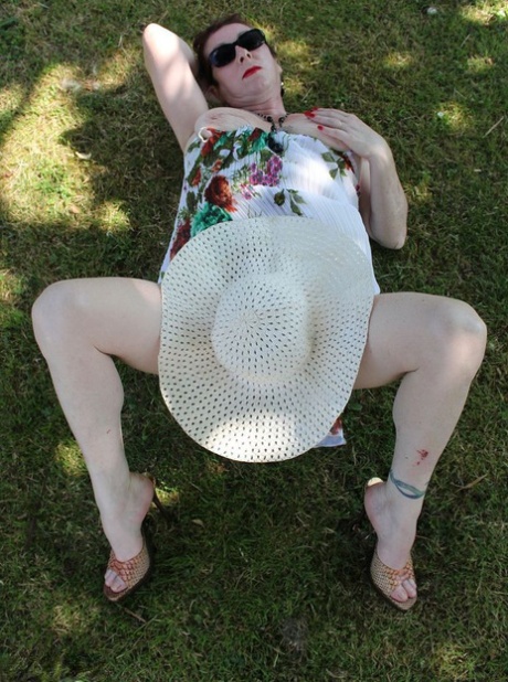 Mature amateur Mary Bitch pulls down her thong on a lawn in a sun hat - pornpics.de