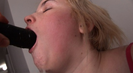 Blonde girl drools while sucking on a black sex toy during POV action