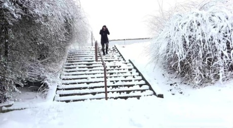 白人女孩亨娜下楼梯，然后在雪地上撒尿