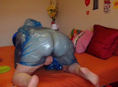 Naked granny Abby Roberts wraps herself in plastic before masturbating