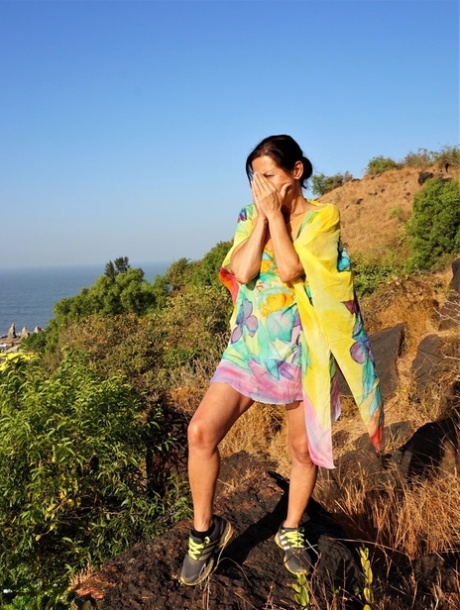 老年妇女戴安娜-阿南塔在徒步前往悬崖顶上的神社时暴露了身体