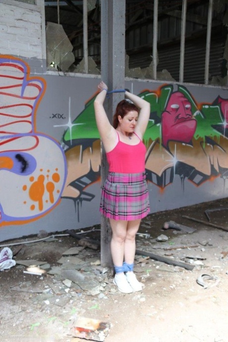 Chubby redhead is fitted with a ball gag and tied to a post and that