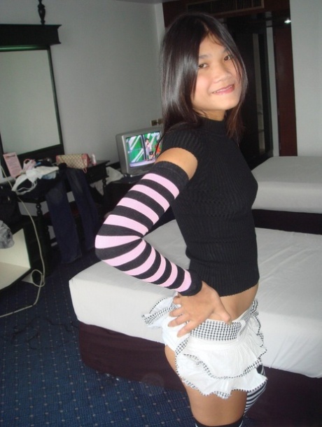 Young Asian girl drinks a beer while disrobing to arm socks and thigh highs - pornpics.de