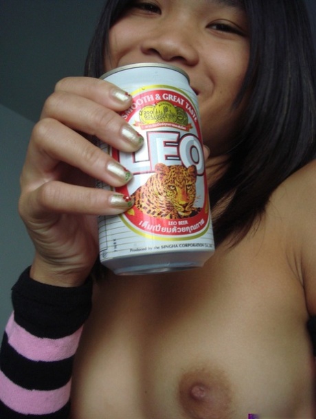 Young Asian girl drinks a beer while disrobing to arm socks and thigh highs - pornpics.de