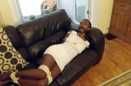 Black female is left tied and cleave gagged in a white dress on a leather sofa - pornpics.de