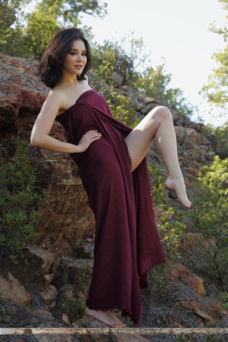 Barefoot teen Malena slips off a long dress to pose nude on a rocky bank - pornpics.de