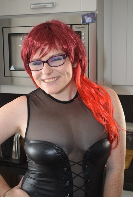 Thick redhead removes leather attire to pose nude before donning nurse garb