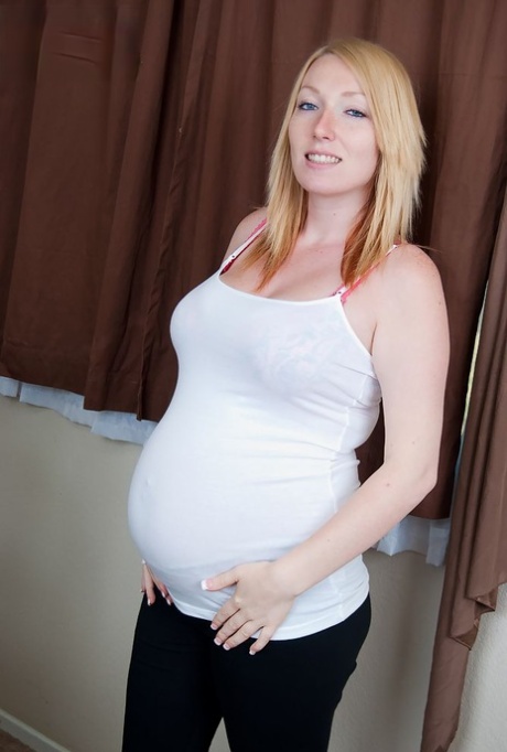 Pregnant girl gets totally naked before masturbating on a chair