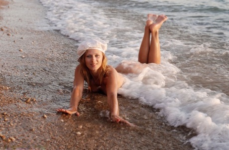 Naked teen Flower takes off her hat while frolicking in ocean surf - pornpics.de