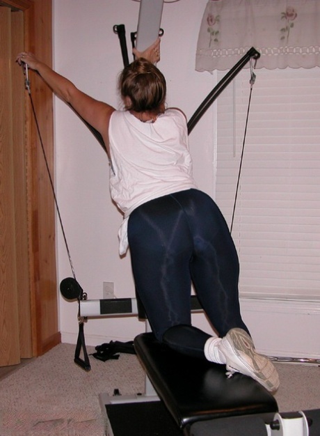 Mature amateur Devlynn exposes her tits and snatch on home gym equipment