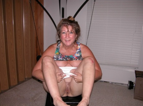 Mature amateur Devlynn exposes her tits and snatch on home gym equipment - pornpics.de