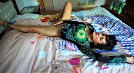 Mature woman Diana Ananta showcases her vagina on top of her bed - pornpics.de