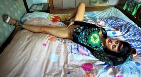 Mature woman Diana Ananta showcases her vagina on top of her bed - pornpics.de
