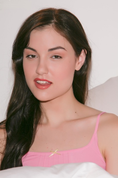 Brunette Sasha Grey lifts her pink shirt to flaunt tiny tits & small nipples