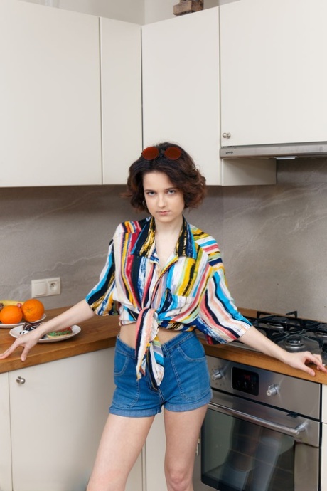 Teen solo girl Polyna gets naked in the kitchen while eating donuts