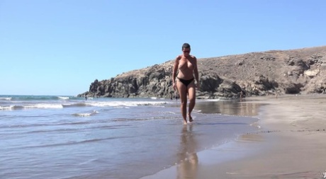 Big titted woman Chloe Lamour squats for a pee while walking on a beach