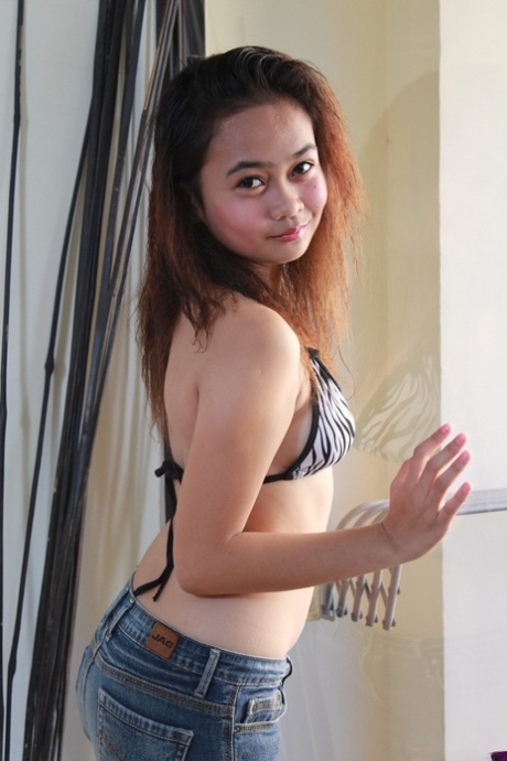 Young Asian girl Rochelle showcases her bald pussy after a striptease - pornpics.de
