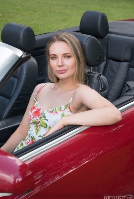 Young blonde Maxine gets naked in a driveway next to a convertible