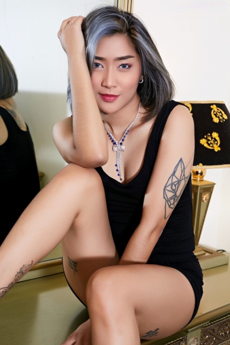 纹身的亚洲宝贝从小黑裙中露出她的小奶子和阴部