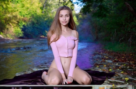 年轻的独身女孩Elle Tan在浅水小溪中完全赤裸。
