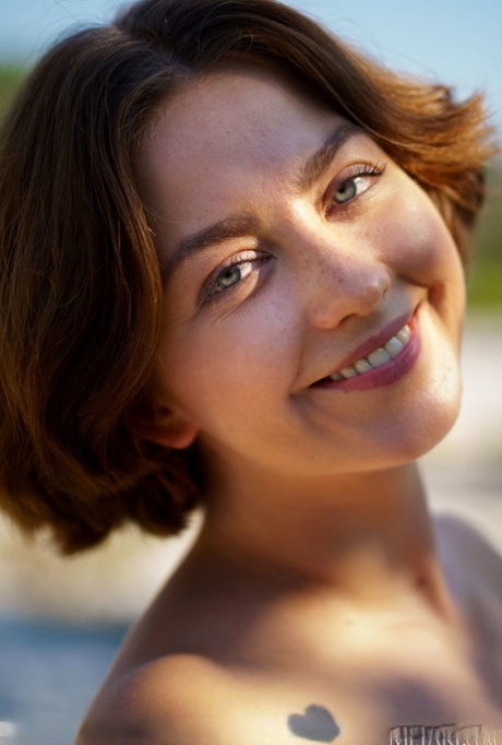 Teen model Amaya sports short hair during a nude gig by a river