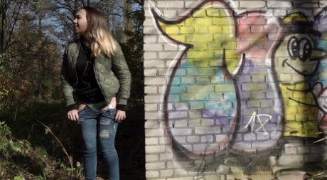 Short taken girl pulls down her jeans to take a piss by a brick building - pornpics.de
